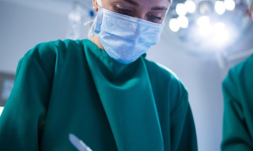 Female surgeon performing operation in operation theater of hospital