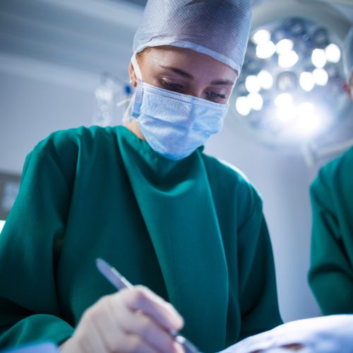 Female surgeon performing operation in operation theater of hospital